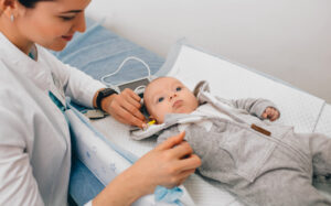 A baby undergoing a hearing test at a pediatric clinic