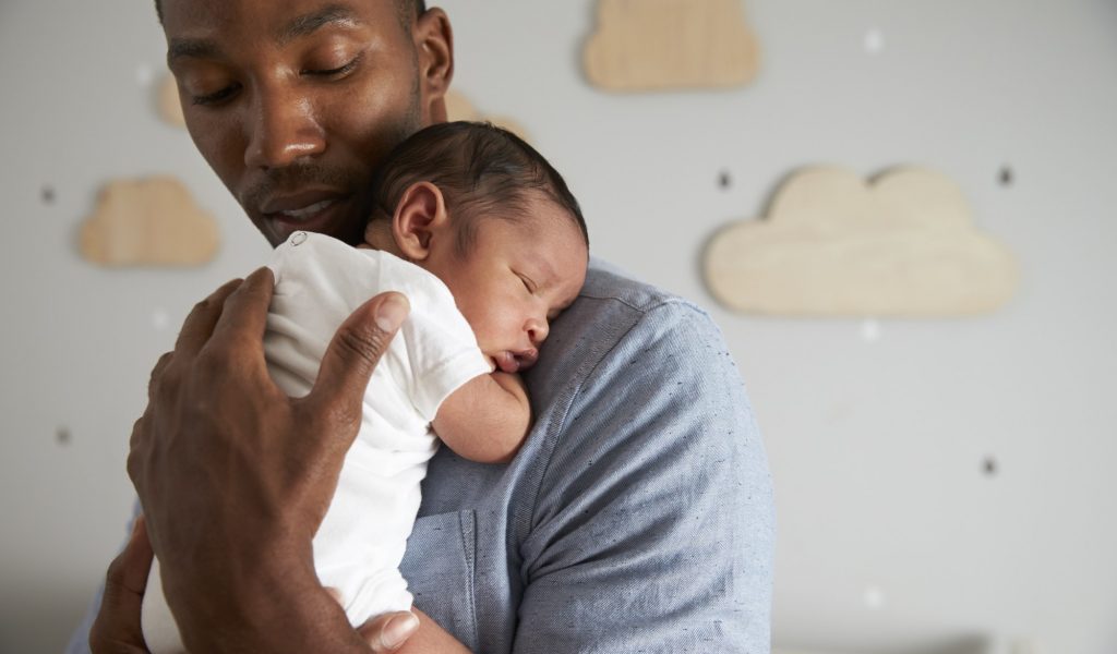 Man holding his newborn child at home